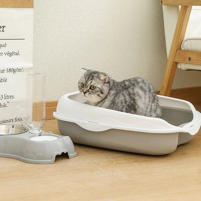 Katze sitzt in grauer halbgeschlossener Toilette